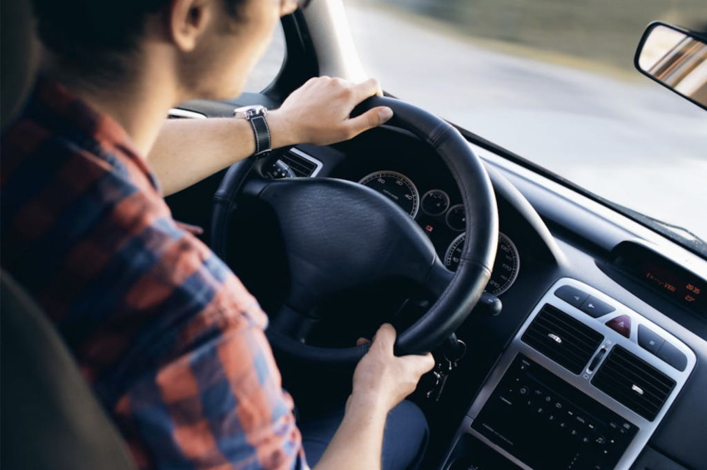 A close up of a man driving a car